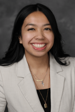 A person in a suit smiling AI-generated content may be incorrect.